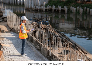 Construction engineer working on a bridge construction site over a river,Civil engineer supervising work,Foreman inspects work at a construction site