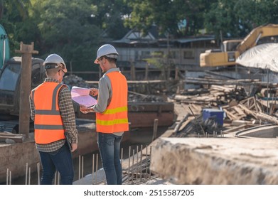 Construction engineer working on a bridge construction site over a river,Civil engineer supervising work,Foreman inspects work at a construction site,Discuss technical problems together