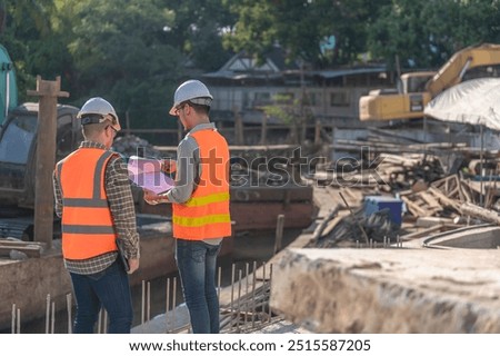 Construction engineer working on a bridge construction site over a river,Civil engineer supervising work,Foreman inspects work at a construction site,Discuss technical problems together