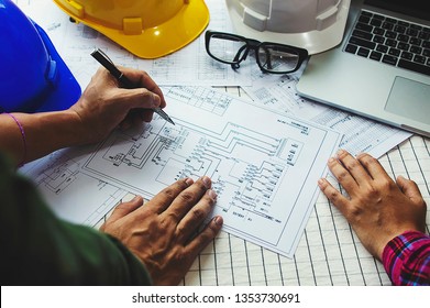Construction engineering or architect discuss a blueprint while checking information on drawing and sketching meeting for architectural project in work site.