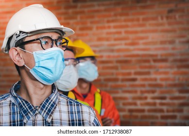 Construction Engineers And Three Architects Wear Medical Masks To Prevent Coronary Infections. Covid-19 - Supervisor And Follower Wearing Masks Stand In The Construction Area.