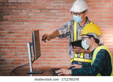 Construction engineers and two architects wear a medical mask to protect the coronary virus, or Covid-19 wears a mask during the design on the computer at the construction site at the desk. - Powered by Shutterstock