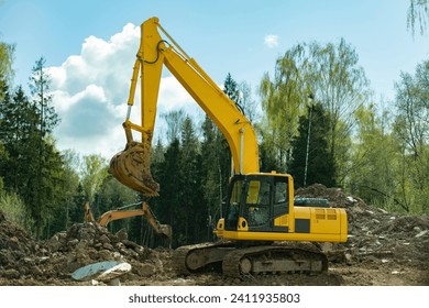 Construction equipment digs ground. Excavated soil. Bucket digs mound. Details of construction of road.