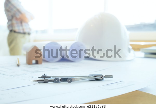 Construction
equipment. Drawings for building Architectural project, blueprint
rolls and divider compass on table. Engineering tools concept. Copy
space of Architecture and Engineer
Desktop.