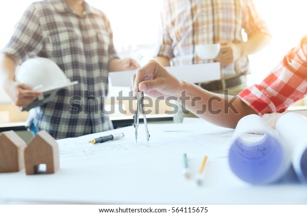 Construction equipment. Repair work. Drawings\
for building Architectural project, blueprint rolls and divider\
compass on table. Engineering tools copy space of Architecture and\
Engineer Desktop.