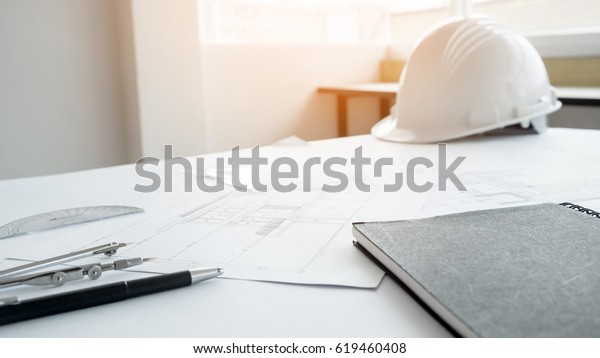 Construction equipment.\
Repair work. Drawings for building Architectural project, blueprint\
rolls and divider compass on table. Engineering tools concept with\
copy space