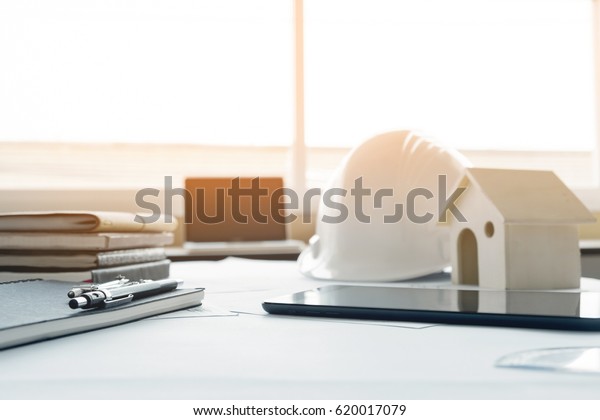 Construction equipment.\
Repair work. Drawings for building Architectural project, blueprint\
rolls and divider compass on table. Engineering tools concept with\
copy space