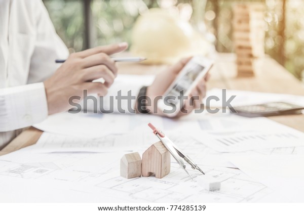 Construction equipment. Repair\
work. Drawings for building Architectural project, blueprint rolls\
and divider compass on table. Engineering tools concept. Copy\
space