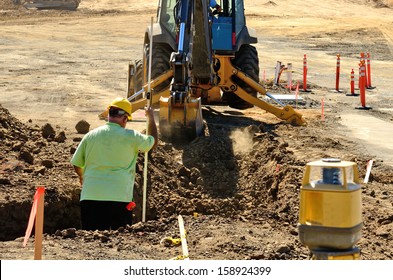 Construction Excavation Contractor Uses A Level Rod And Laser To Dig A Trench For A Concrete Foundation Wall