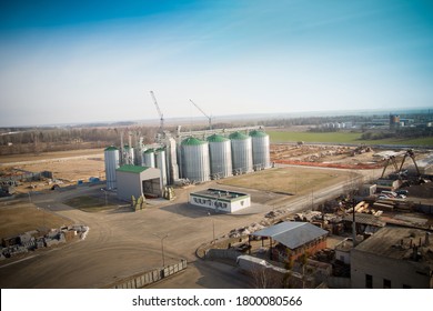 Construction of a feed mill agro-processing plant for processing and silos for drying cleaning and storage of agricultural products, flour, cereals and grain. Silver tanks view from afar.