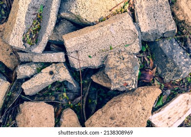 Construction Garbage. Broken Building Blocks Are Thrown On The Green Grass. Environmental Pollution