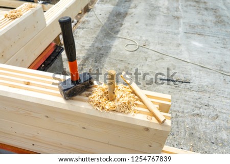 Construction of the house from a bar. Drilling holes and clogging of dowels.