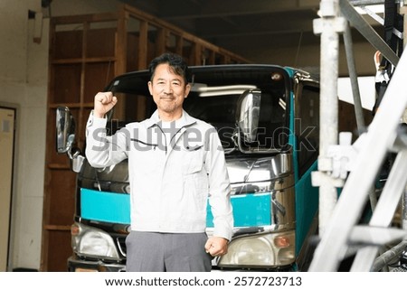 Construction image of a middle-aged man posing in front of a truck