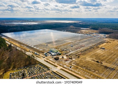 Construction of industrial greenhouses aerial view under blue cloudy sky. Feeding the planet, feeding people.