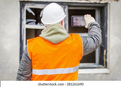 Construction Inspector Filming With Cell Phone Near Building 