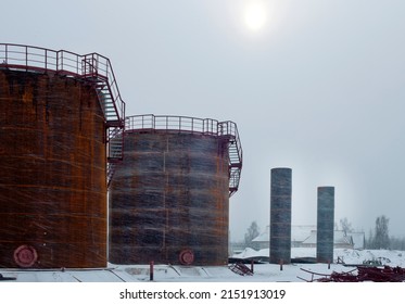 Construction of large fuel tanks during a snowstorm in winter - Shutterstock ID 2151913019