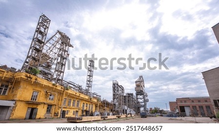 The construction of a large ship on a shipyard with cranes timelapse hyperlapse. A fragment of the case in the yellow workshop of the plant. Metal frame during assembly