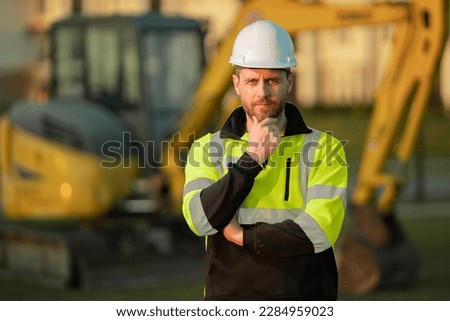 Construction man with excavator at industrial site. Worker in helmet build with bulldozer. Engineer work with builder contractor in hardhat. Excavation foreman with tractor. Workman with excavator.