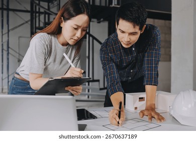 Construction manager and engineer dressed in orange work vests and hard helmets explore construction documentation on the building site near the steel frames - Powered by Shutterstock - Get 15% off with code: PIKWIZARD15