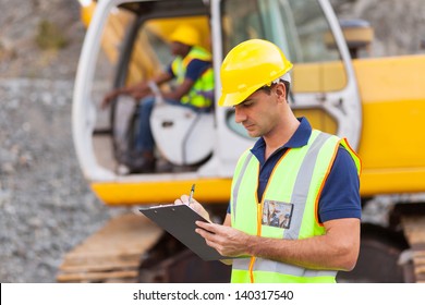 Construction Manager Writing Report At Construction Site