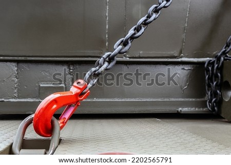 construction or military equipment is held by tension safety chains with hooks. Cargo transportation