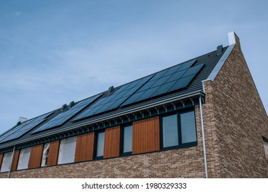 
The Construction Of Modern New Houses That Are Energy Efficient And Sustainable In The Netherlands. A Zero Energy Home With Unique Architecture And Solar Panels On The Roof.