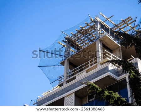 Construction nets on an unfinished building. Construction industry. Cement and concrete. Safety