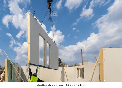 Construction New And Modern Modular House From Composite Sip Panels. Worker Man In Uniform Wear Working On Building Development Industry Of Energy Efficient Property Against Blue Sky Background