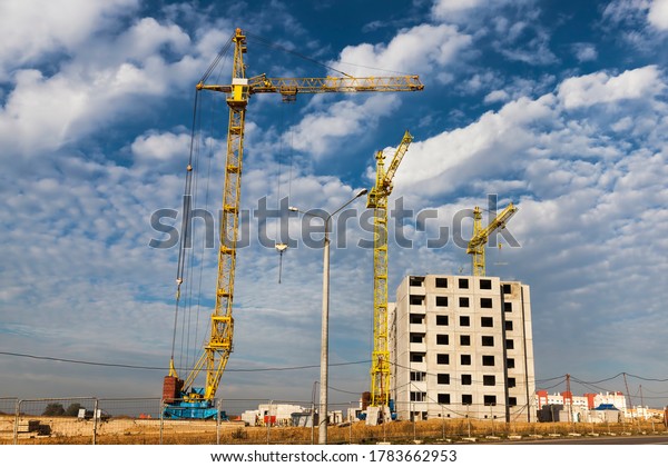 construction of a new\
multi-storey building for people to live in apartments, the\
building is being built using a high construction crane against the\
background of clouds in the\
sky