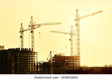 Construction of new residential high-rise buildings. Against the background of a yellow sunset sky. - Shutterstock ID 1936910641