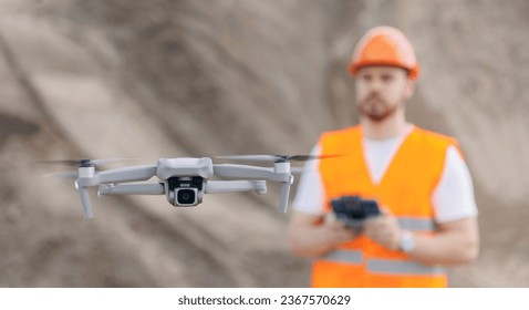 Construction operator worker piloting drone at industry building site. Concept industrial inspection from pilot engineer.