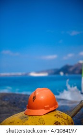 Construction Orange helmet lies berth against the blue sea and sky