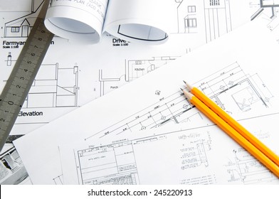 Construction planning drawings on the table and two yellow pencils with ruler