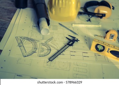 Construction plans with helmet and drawing tools on blueprints  ( Filtered image processed vintage effect. )