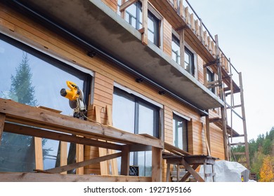 Construction Of A Private House. Wood Paneling Of The Facade Of The Cottage. Country House Is Being Built In The Countryside. New Cottage With Exterior Wood Trim. House Is Covered With Wooden Panels.