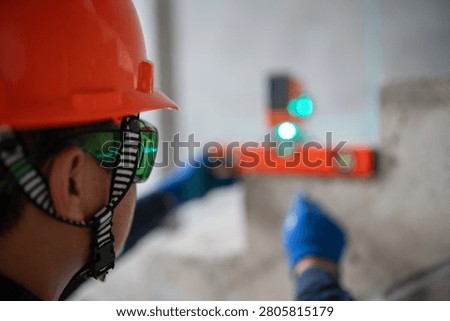 Construction professional utilizing a laser leveling tool for accuracy in a building project