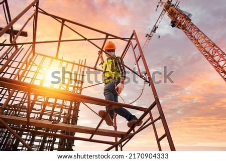 Construction professional workers wear safety harnesses and safety cables working in hospital construction scaffolding.
