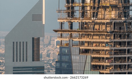 Construction progress of new modern skyscraper in Dubai city aerial timelapse, United Arab Emirates. Cranes and building equipment in financial district near downtown