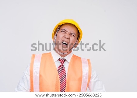 A construction project manager or engineer in a safety helmet and vest looking very frustrated and cussing. Isolated on a white background.