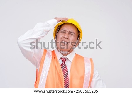 A construction project manager or engineer in a safety helmet and vest looking very frustrated and cussing. Isolated on a white background.