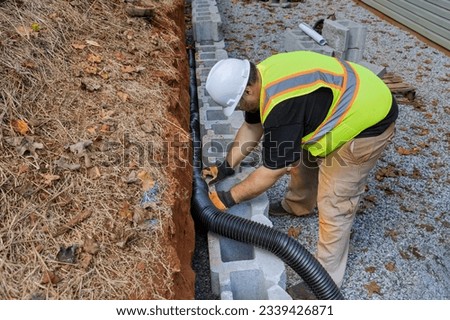 Construction project on proper installation of drainage pipe for rainwater in retaining wall.