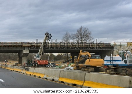 Construction for renewing damages on pillars of concrete bridge of a under renovation road modern road interchange in USA