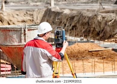 Construction of a residential area. Geodetic stakeout. Surveyor at a large construction site. A man with a tachometer during work. Makshader