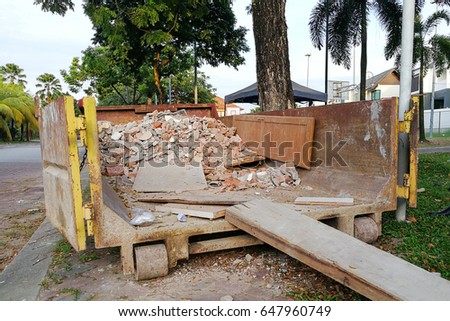 Construction rubbish bin dumpster with loads at construction site for disposal