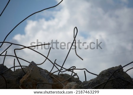 Construction rubble. Rebar reaching for cloudy sky. Cement and rebar.