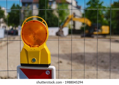 Construction safety. Street barricade with warning signal lamp on a fence. Blur site background - Shutterstock ID 1988045294