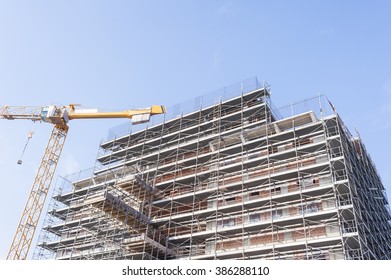 Construction Scaffolding Of A Building Under Construction And A Crane.