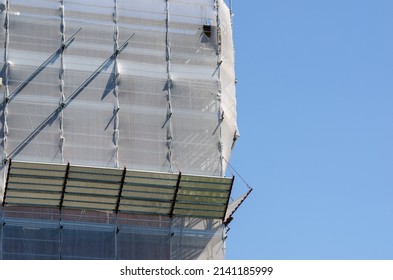 Construction: Scaffolding structure with fall protection sheet. Facade structure for building maintenance.