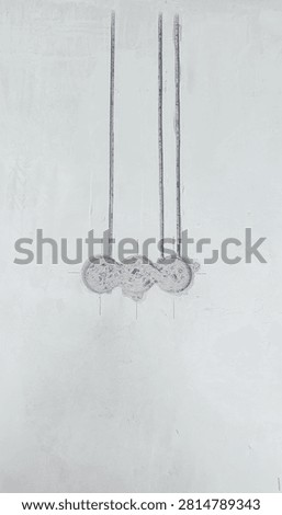 Construction scene: three vertical channels drilled into a concrete wall for wiring, with back boxes prepared for outlets.