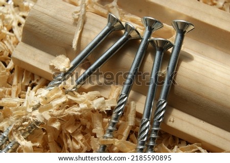 Construction screws wood shavings on board. Silver screws.